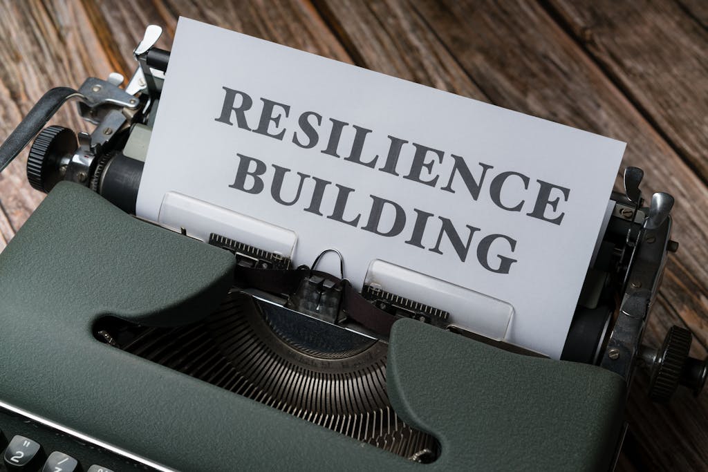 A typewriter with the word resilience building on it