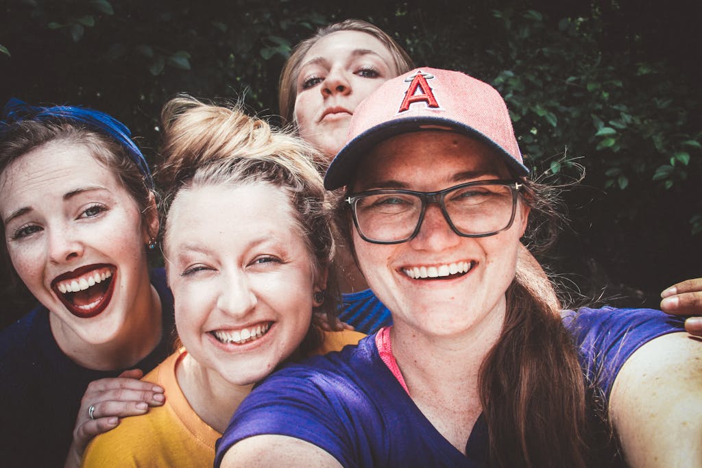 Four Women in Front of Green Bushes