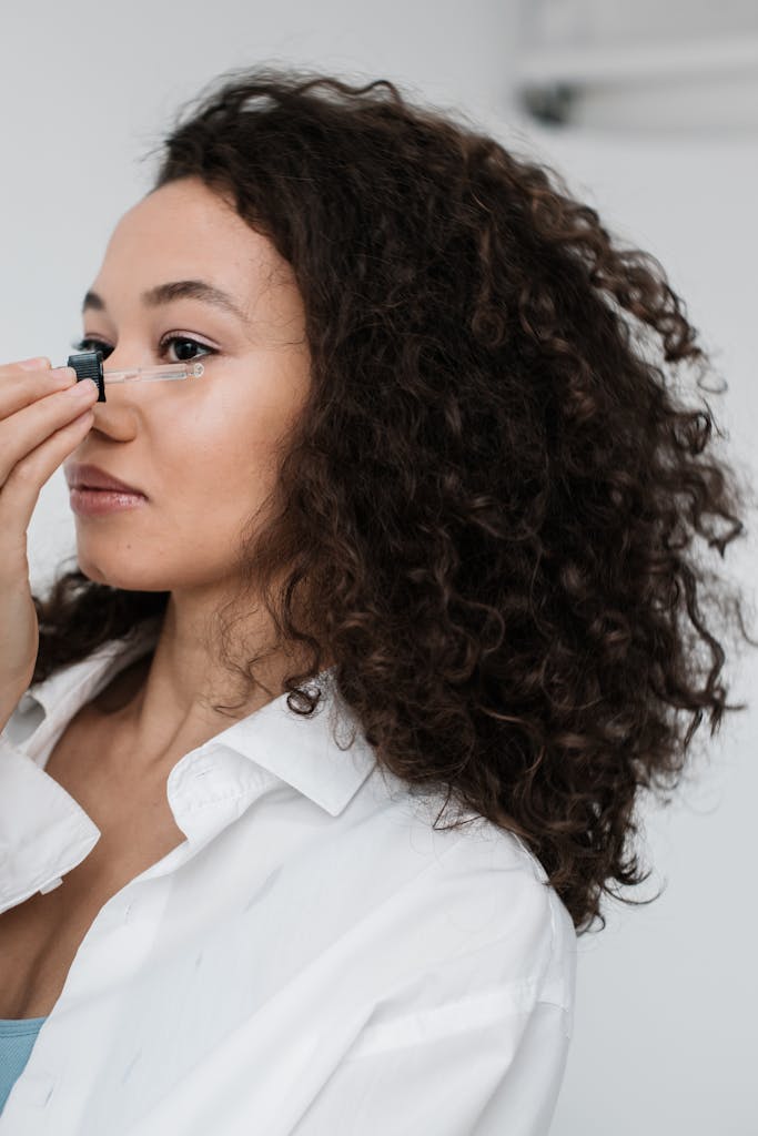 Applying face oil for glowing skin.