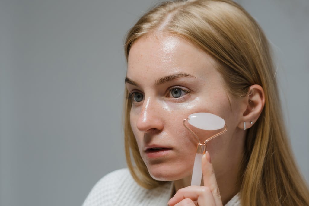 Woman Doing Face Massage With A White Jade Roller. Massager tools.