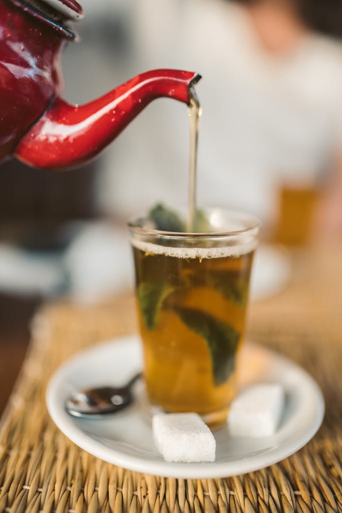 A Person Pouring Tea in the Cup