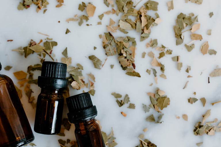 Essential Oil Bottles and Herbal Medicine on White Surface