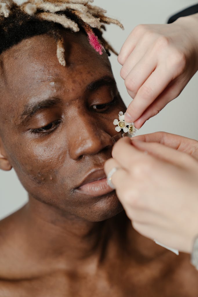 Man With White and Gold Flower on His Ear