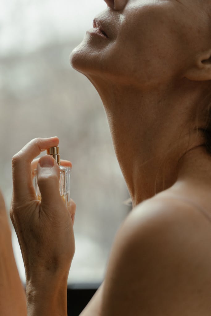 Woman spraying Perfume on her Neck