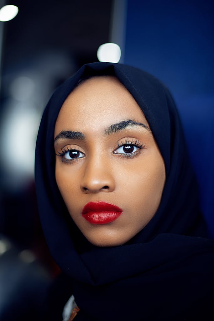 Woman Wearing Black Hijab and Red Lipstick Looking at Camera