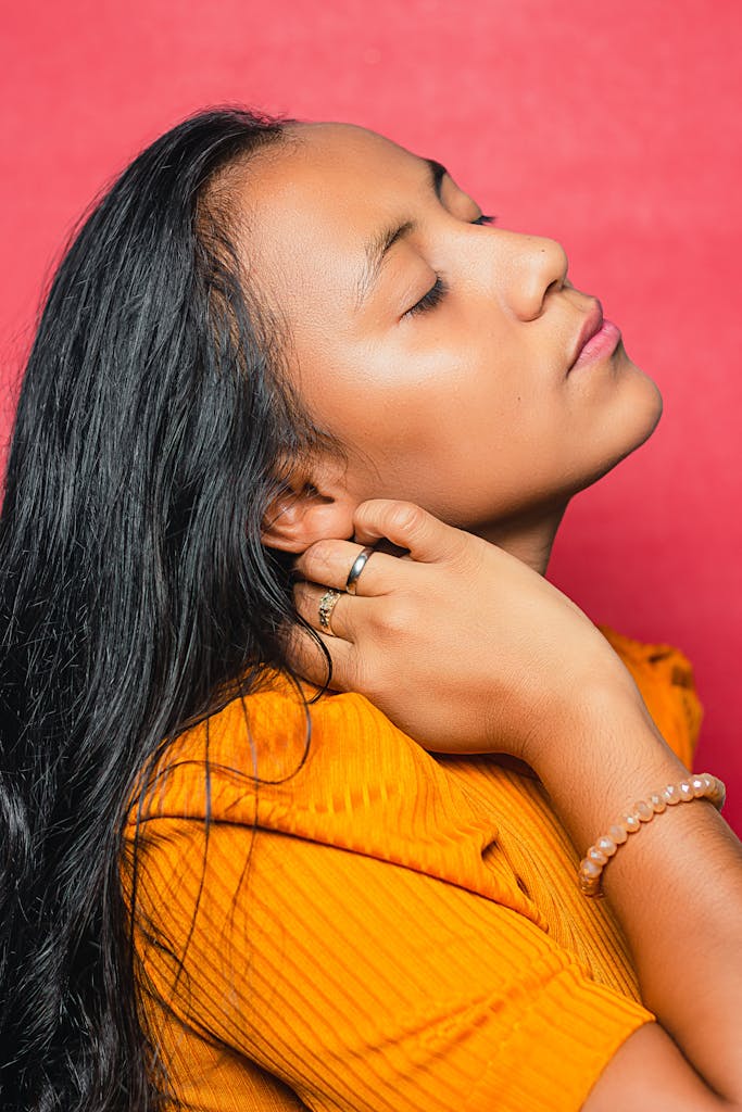 Reflective ethnic woman with closed eyes on red background