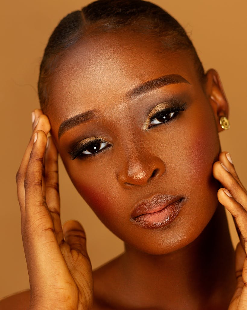 Close-up portrait of a woman with rich brown skin and stunning makeup.