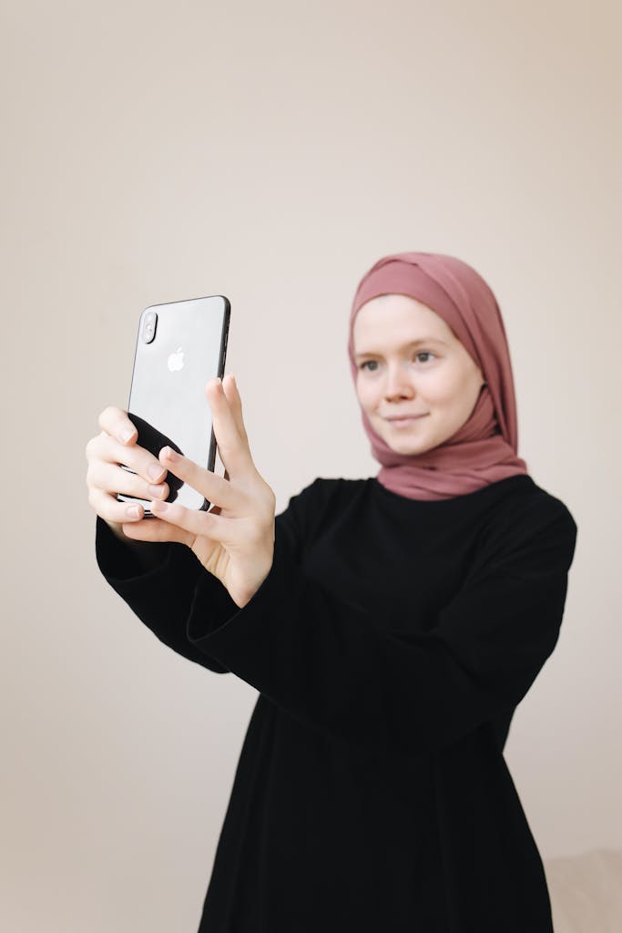 Young woman in hijab checking out skincare apps for smart skincare.